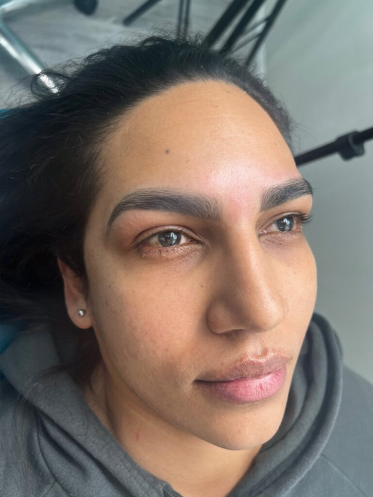Olive skinned woman showing off her fresh beautiful Custom Brow & Tint Design by Bare Fruit Sugaring
