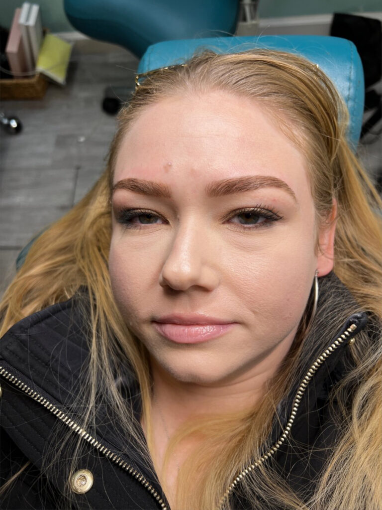 Blond woman shows off her bold beautiful blonde blond henna eyebrows from bare fruit sugaring