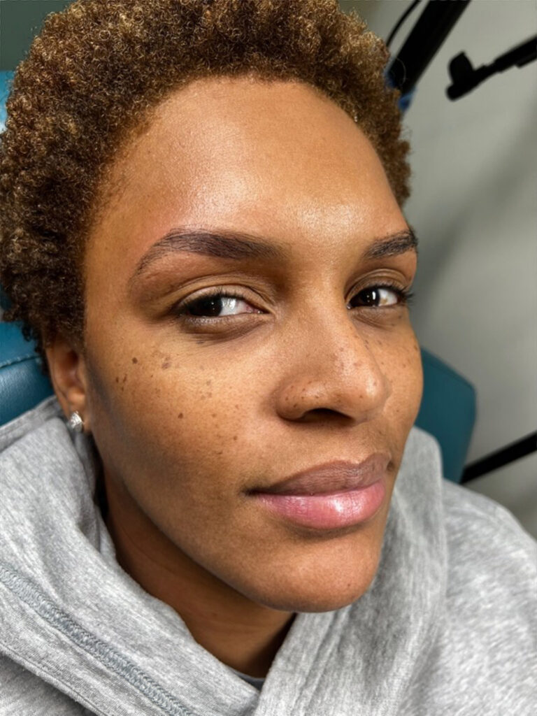 Black woman with beautiful bold brows after Bare Fruit Sugaring brow design and makeup services