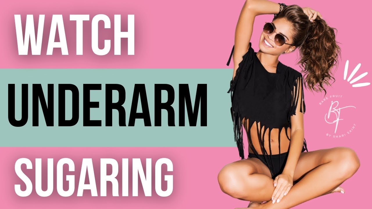 Watch Underarm Sugaring featuring Flirty young tanned brown skinned woman in a black knotted crop top and shorts posing next to the Bare Fruit by Shari Saint women sugaring services photo